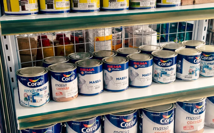 Prateleira com latas de tinta de várias marcas